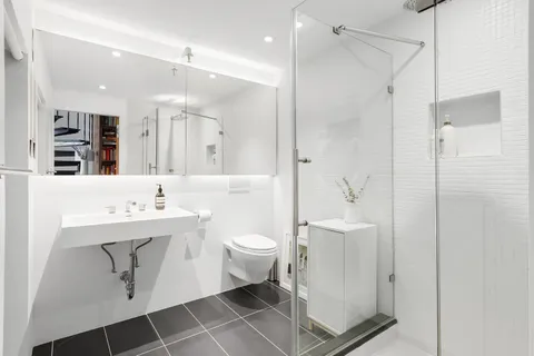 a bathroom with a sink a toilet and shower