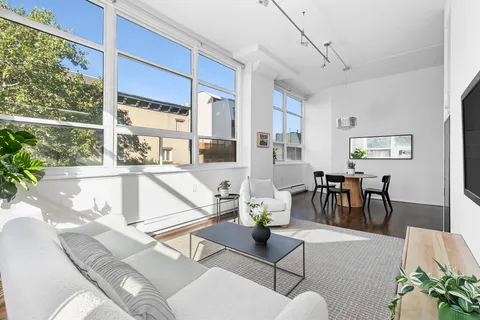 a living room with furniture a dining table and a large window