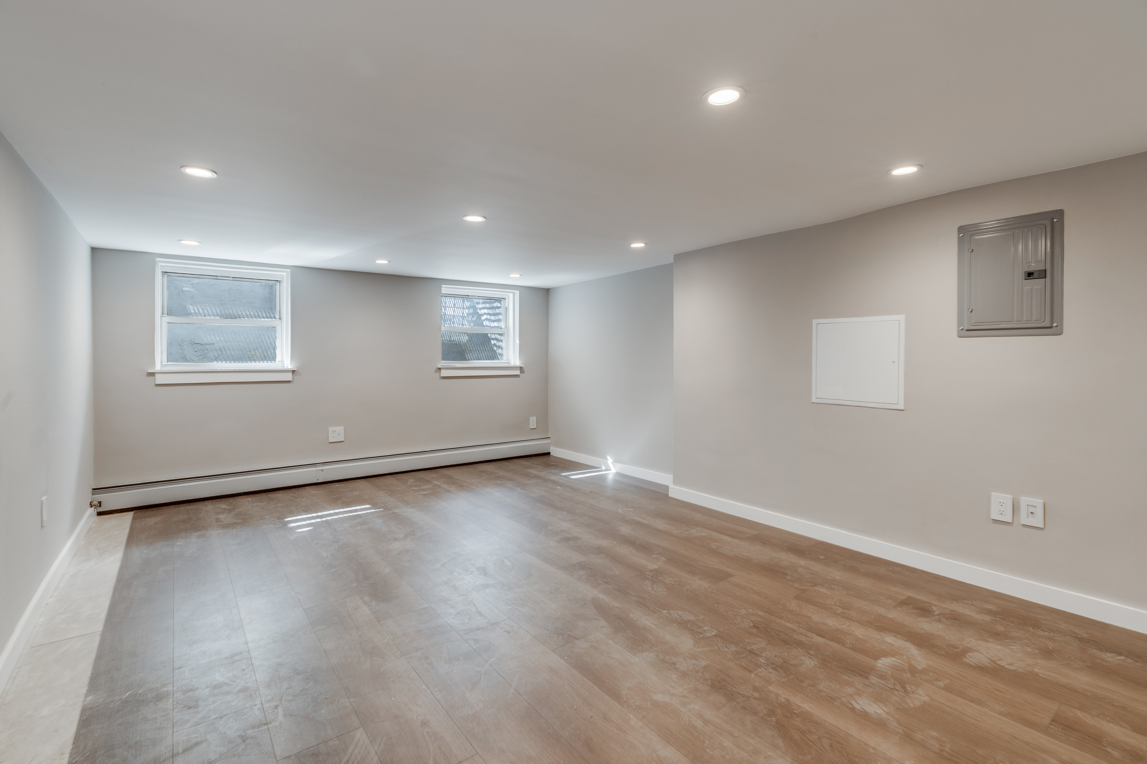 464 West 23rd Street, Unit 1R Manhattan, NY 10011 - Photo 5 of 9 an empty room with wooden floor and windows