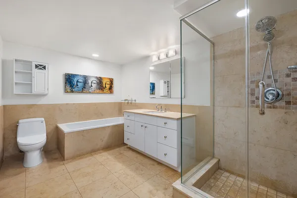 a bathroom with a tub sink toilet and a shower