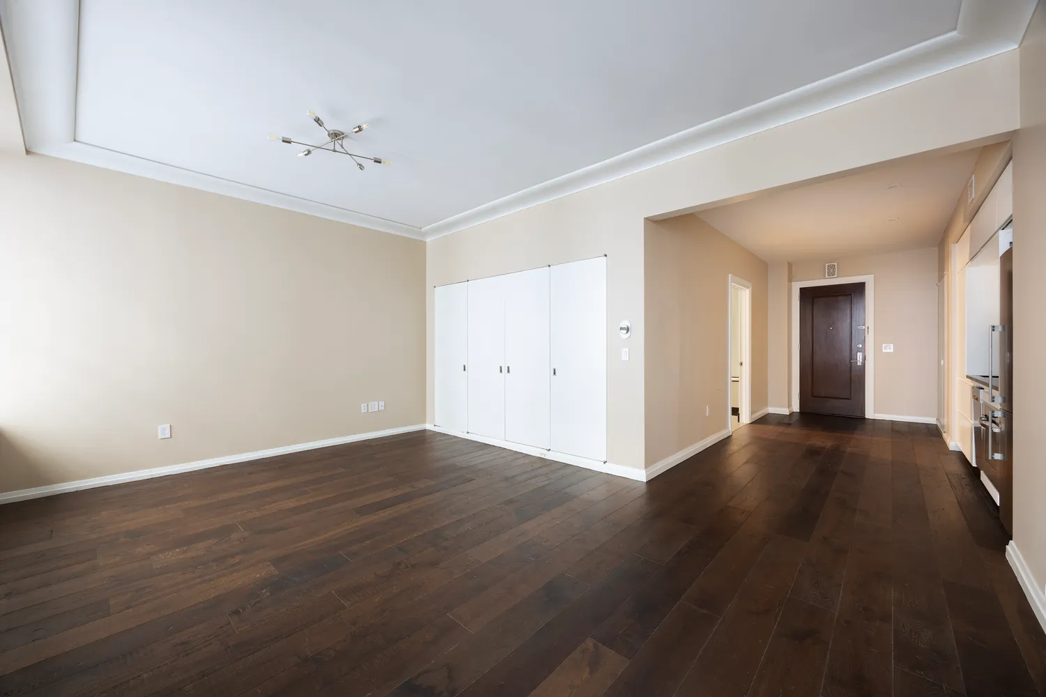 a view of an empty room with wooden floor