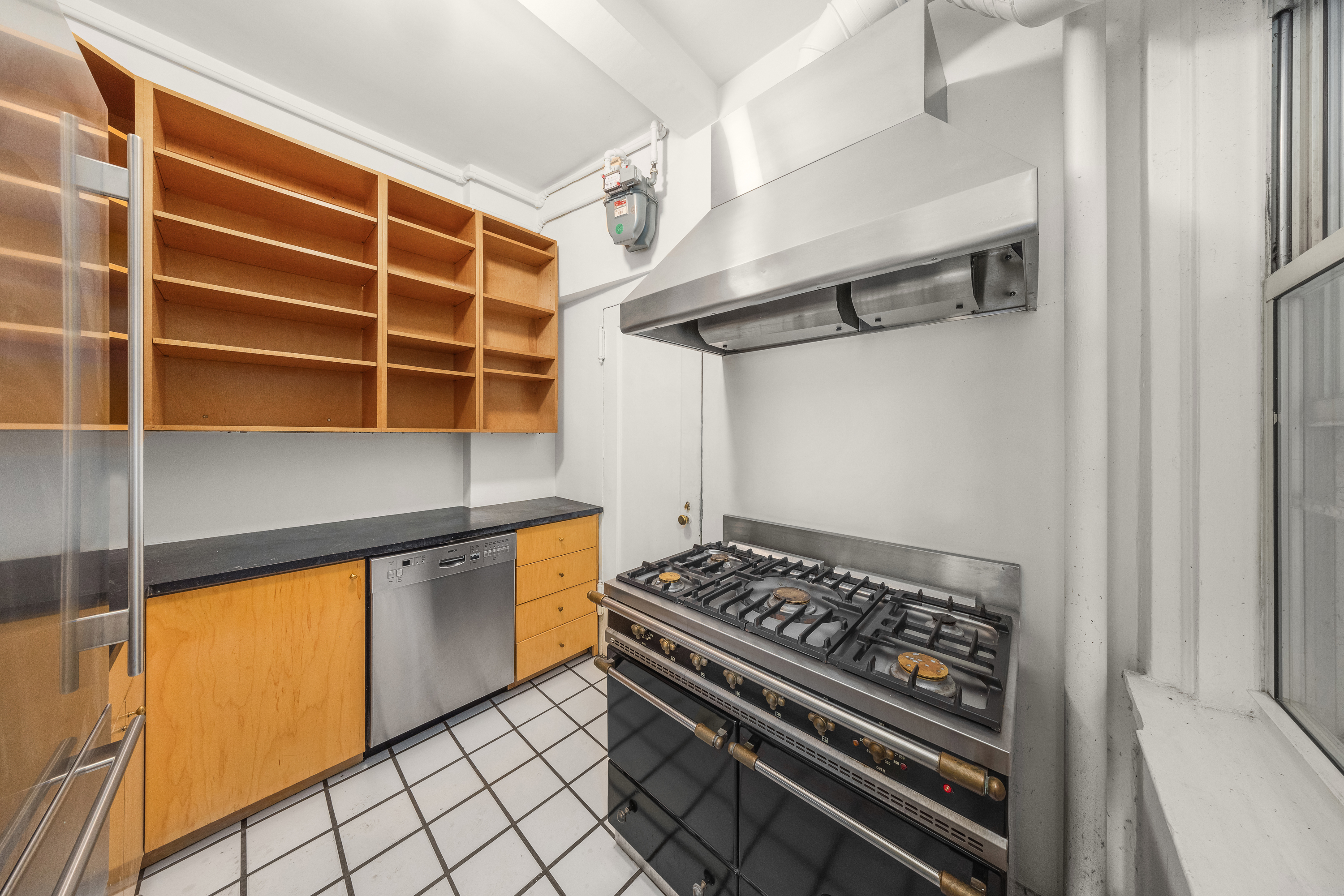 39 5th Avenue, Unit 2B Manhattan, NY 10003 - Photo 5 of 10 a kitchen with stainless steel appliances a stove and a refrigerator