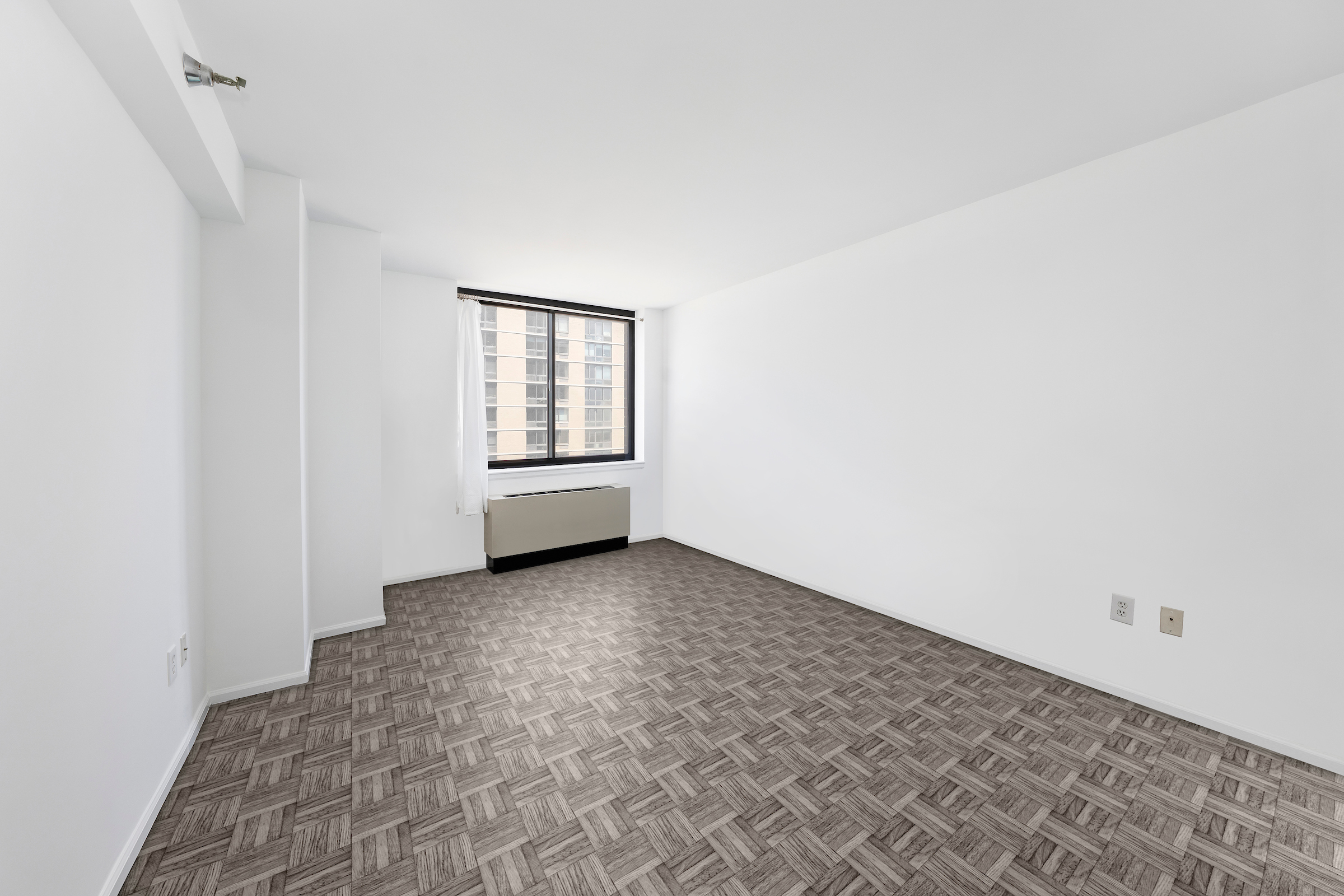 4-74 48th Avenue, Unit 19B Queens, NY 11109 - Photo 6 of 10 an empty room with windows