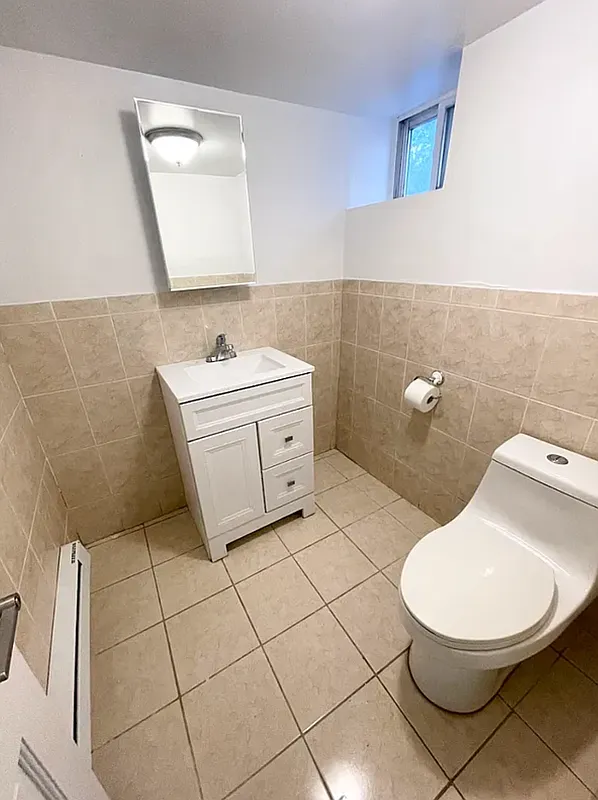 1128 Bushwick Avenue, Unit A Brooklyn, NY 11221 - Photo 11 of 14 a bathroom with a sink mirror vanity and toilet