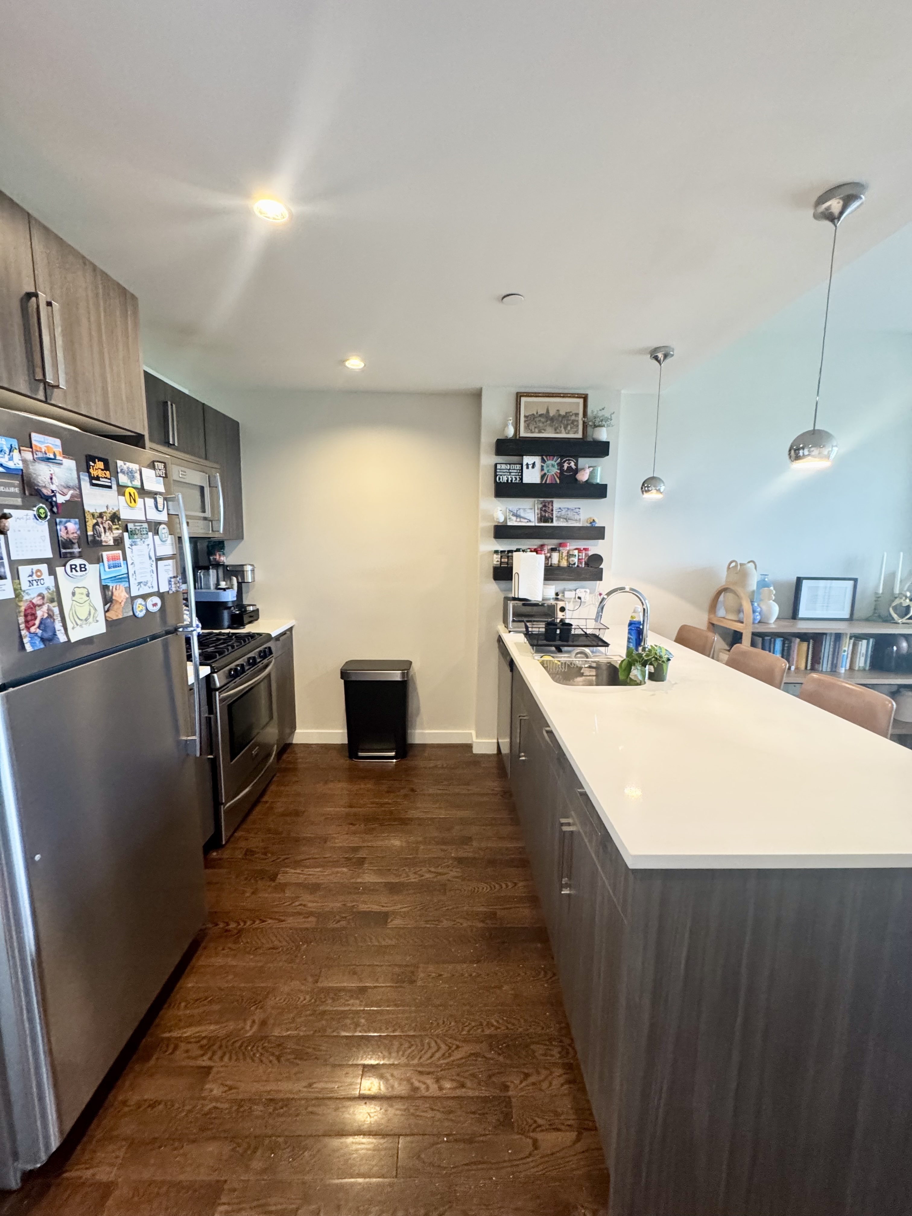 Broadway, Unit 306 Queens, NY 11106 - Photo 4 of 7 a kitchen with kitchen island a stove a sink and a refrigerator
