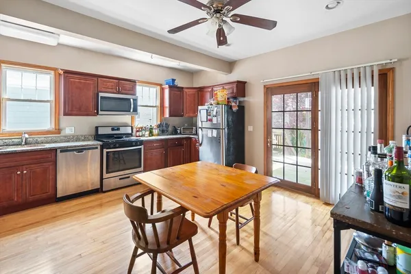 a kitchen with stainless steel appliances granite countertop wooden floor stove top oven and cabinets
