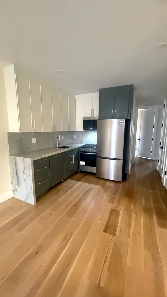 a large kitchen with a refrigerator a stove a microwave and cabinets