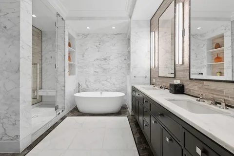 a spacious bathroom with a bathtub shower sink mirror and toilet