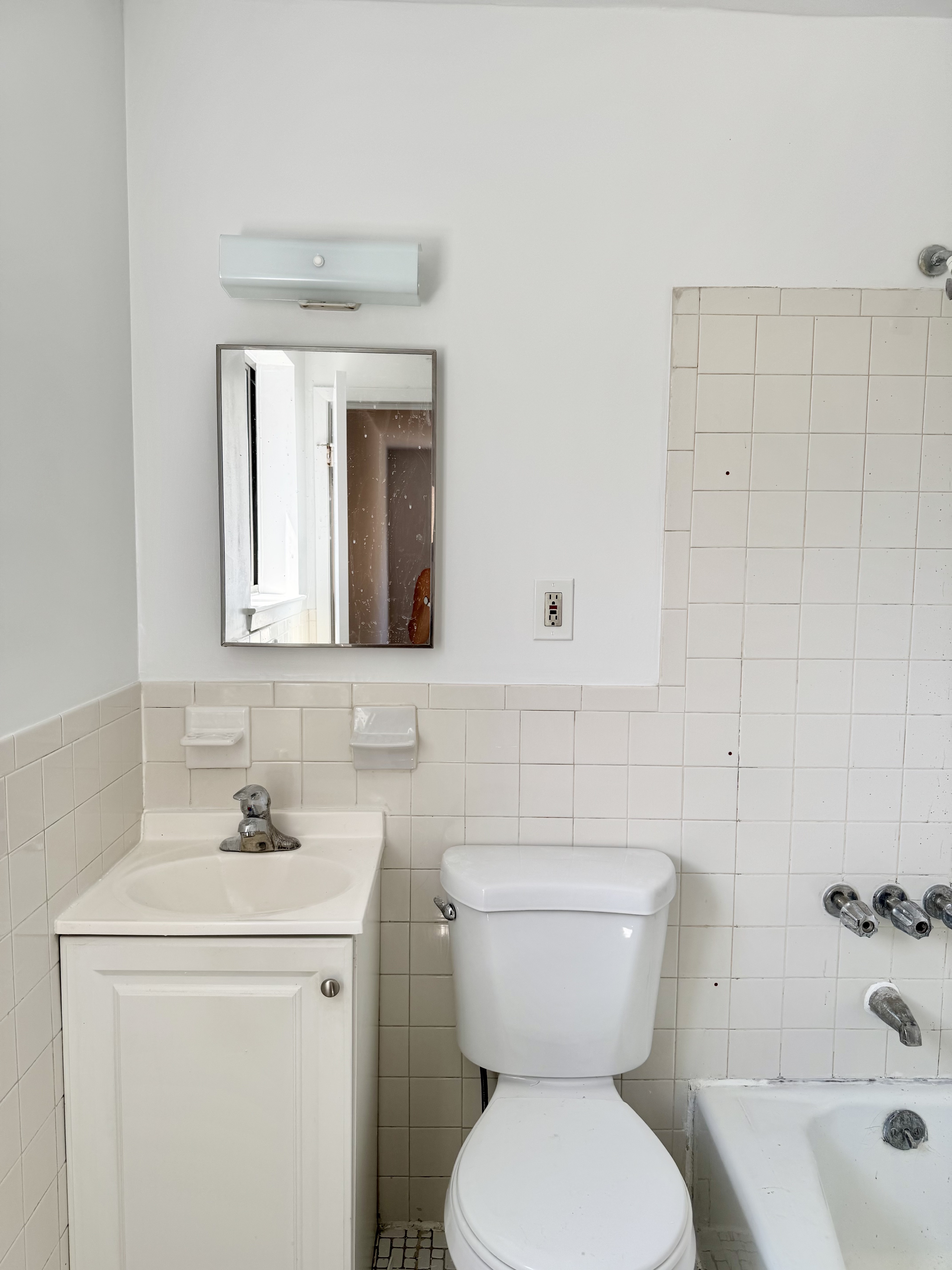 59-15 39th Avenue, Unit 2 Queens, NY 11377 - Photo 9 of 13 a bathroom with a toilet sink and mirror
