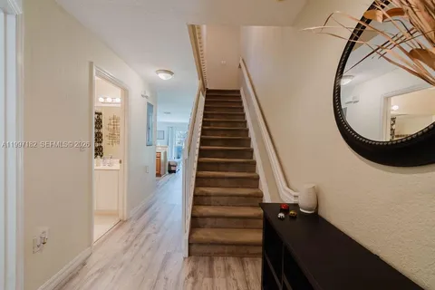 a view of entryway and hall with wooden floor