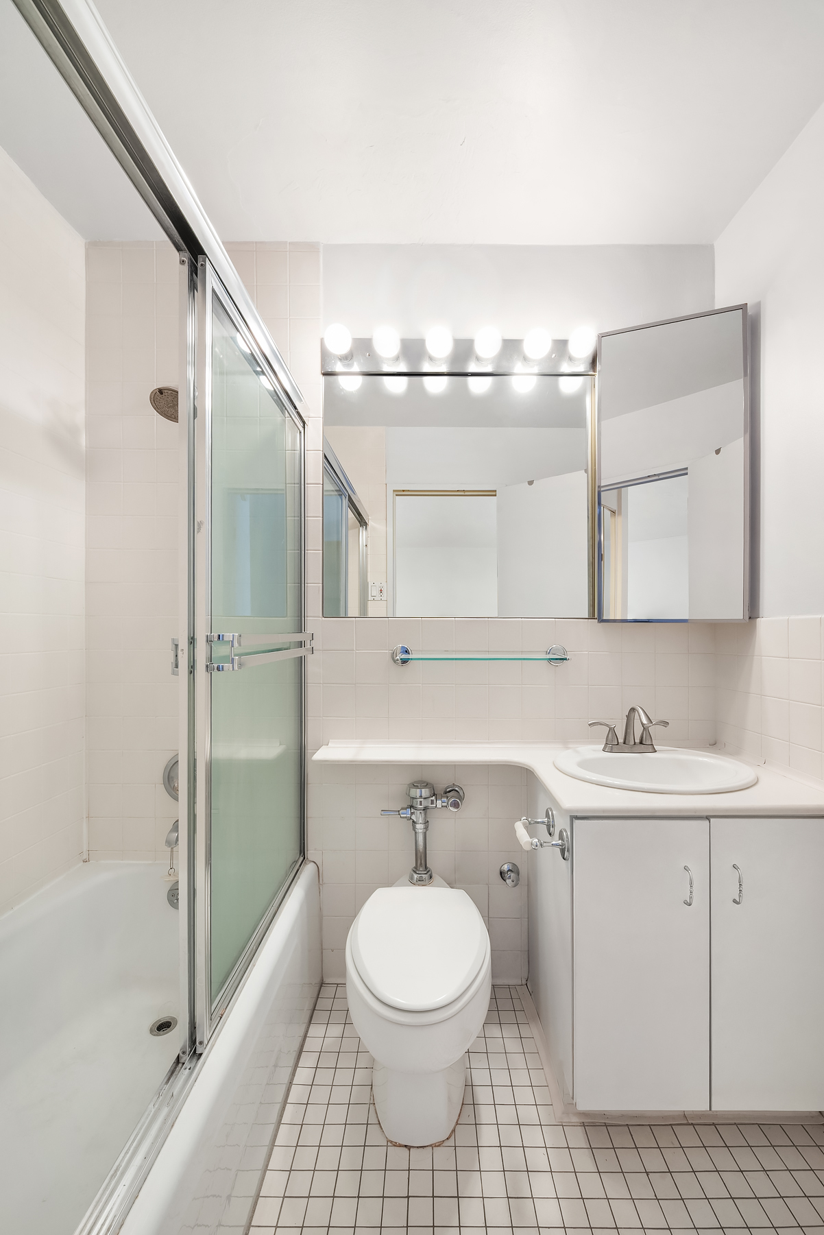 301 East 64th Street, Unit 4J Manhattan, NY 10065 - Photo 3 of 5 a bathroom with a sink a toilet and shower