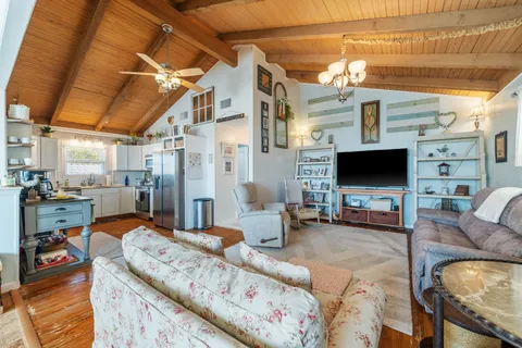 a living room with furniture a flat screen tv and a table