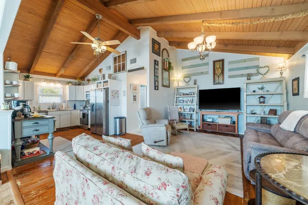 a living room with furniture a flat screen tv and a table
