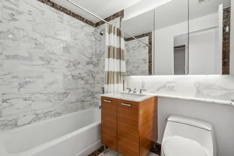 a bathroom with a sink toilet vanity and shower