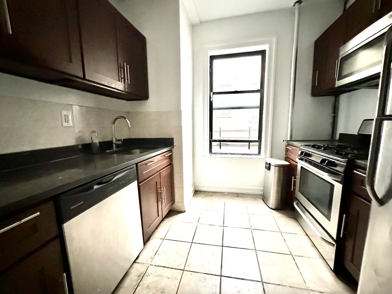 a kitchen with granite countertop a stove a sink and a microwave