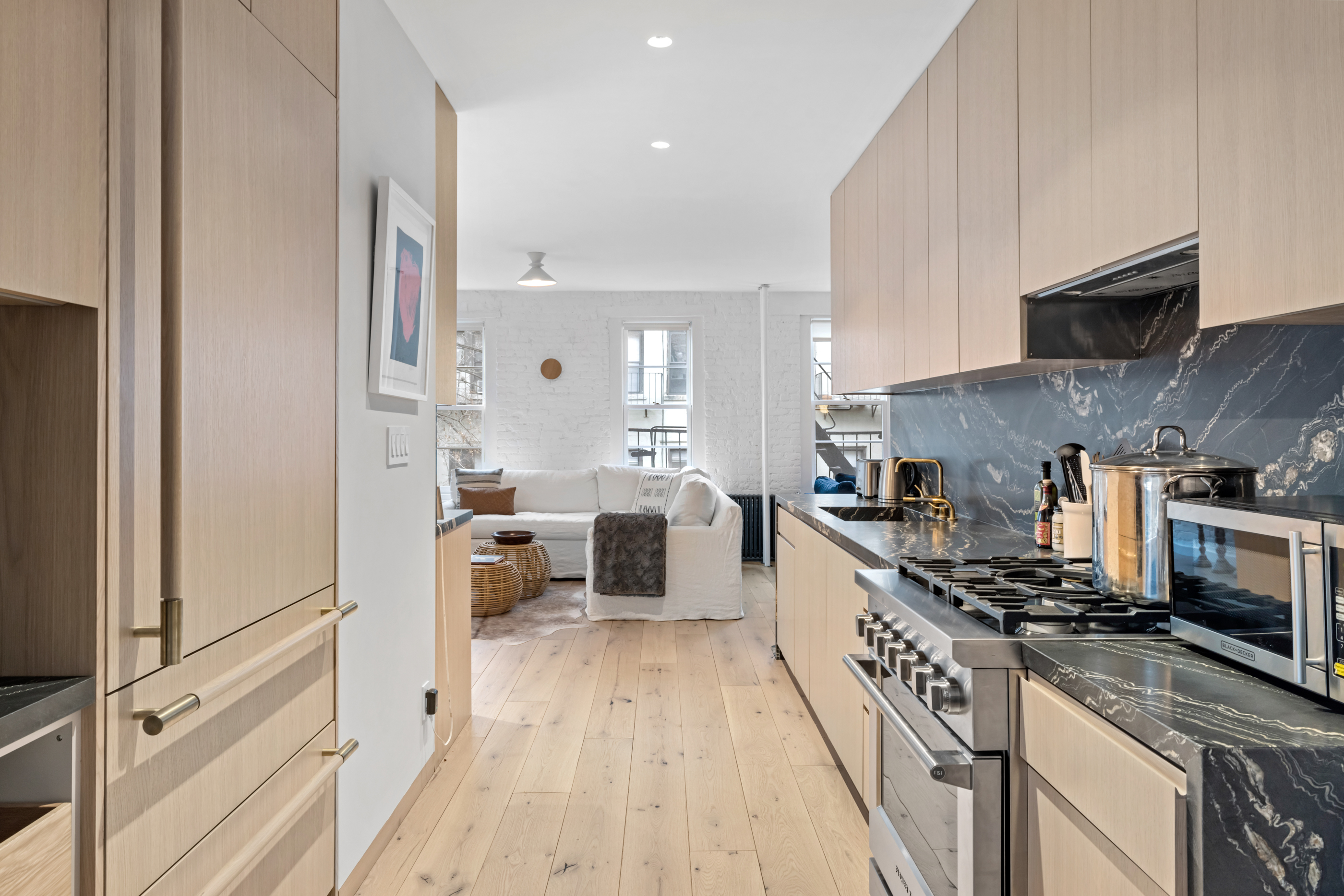 57 Thompson Street, Unit 4E Manhattan, NY 10012 - Photo 3 of 16 a kitchen with stainless steel appliances a stove a sink and a refrigerator