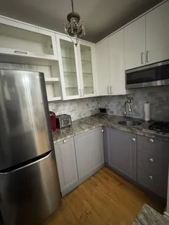 a kitchen with stainless steel appliances granite countertop a refrigerator a sink a stove and white cabinets