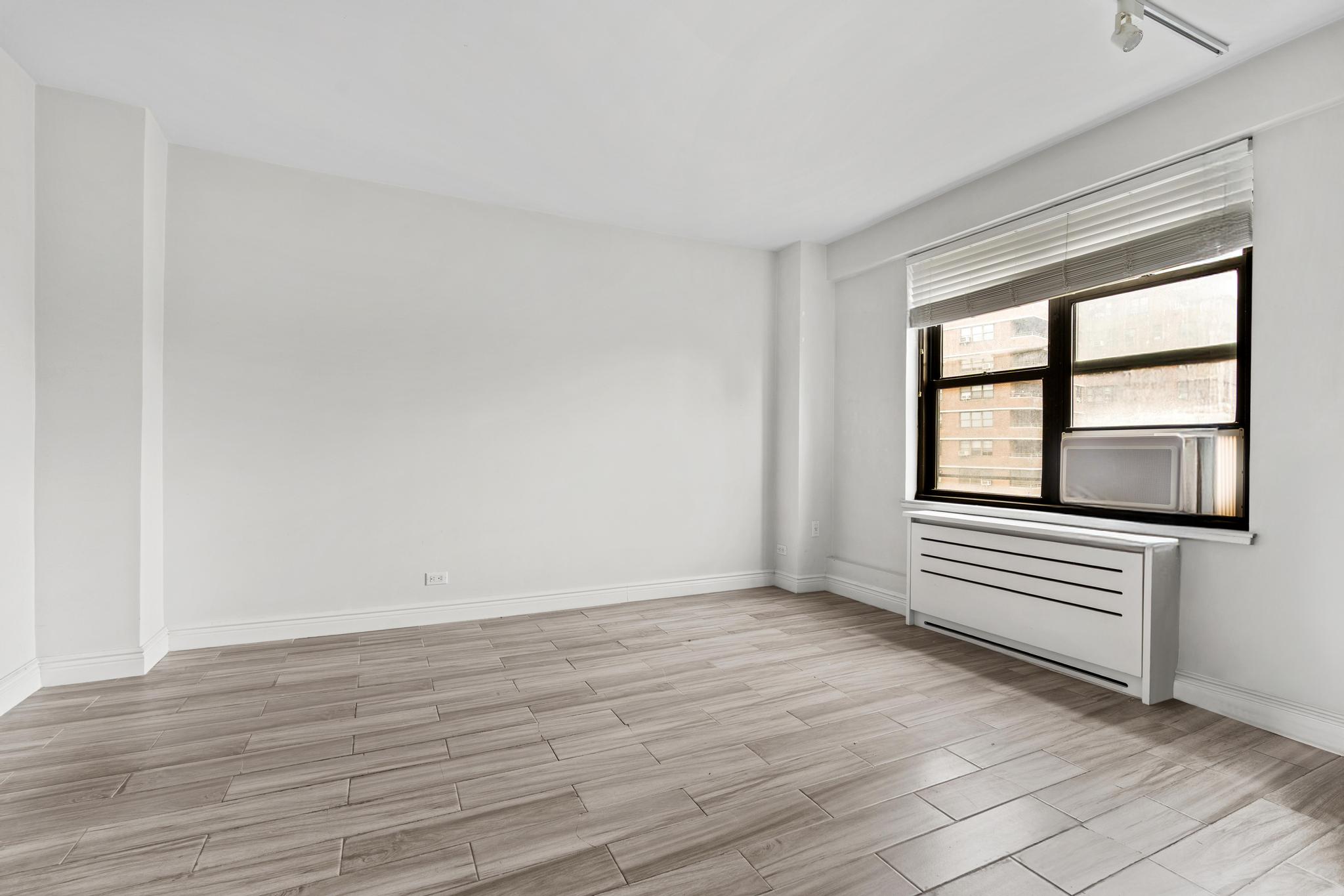 266 East Broadway, Unit 1304B Manhattan, NY 10002 - Photo 6 of 8 wooden floor in an empty room with a window