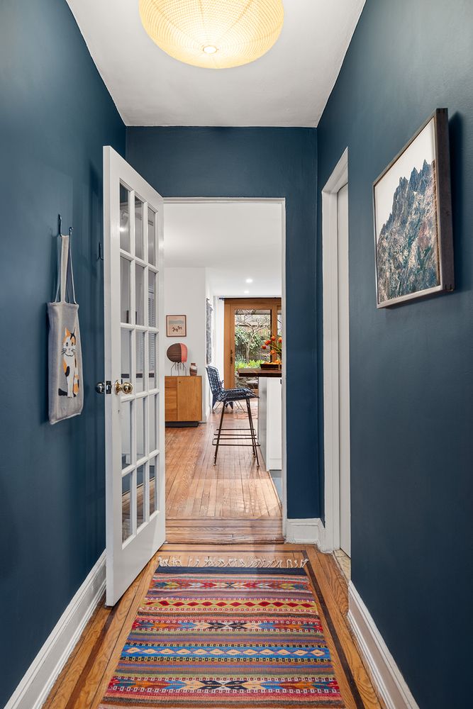a view of a hallway with wooden floor and furniture