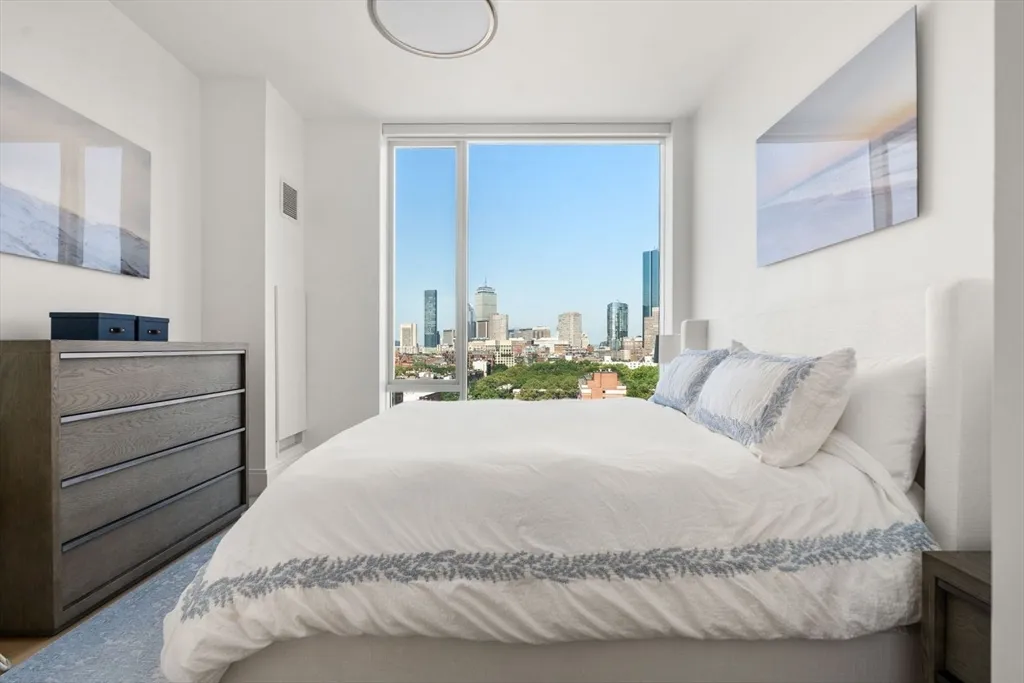 a bedroom with a bed and with a white comforter