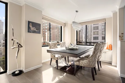 a view of a a dining room with furniture window and wooden floor