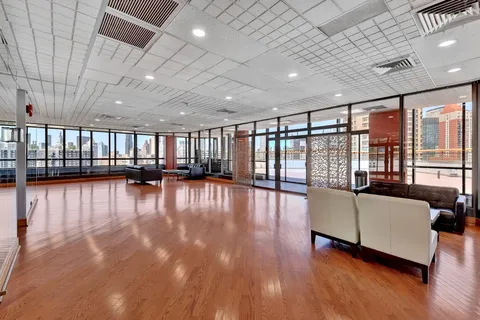 a living room with furniture floor to ceiling window and an outdoor view