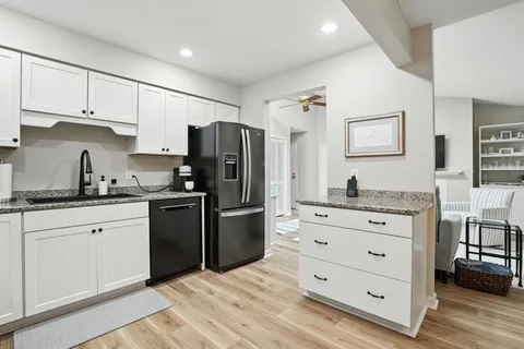 a kitchen with granite countertop cabinets and refrigerator