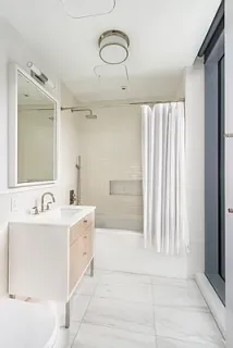 a bathroom with a double vanity sink mirror and bathtub