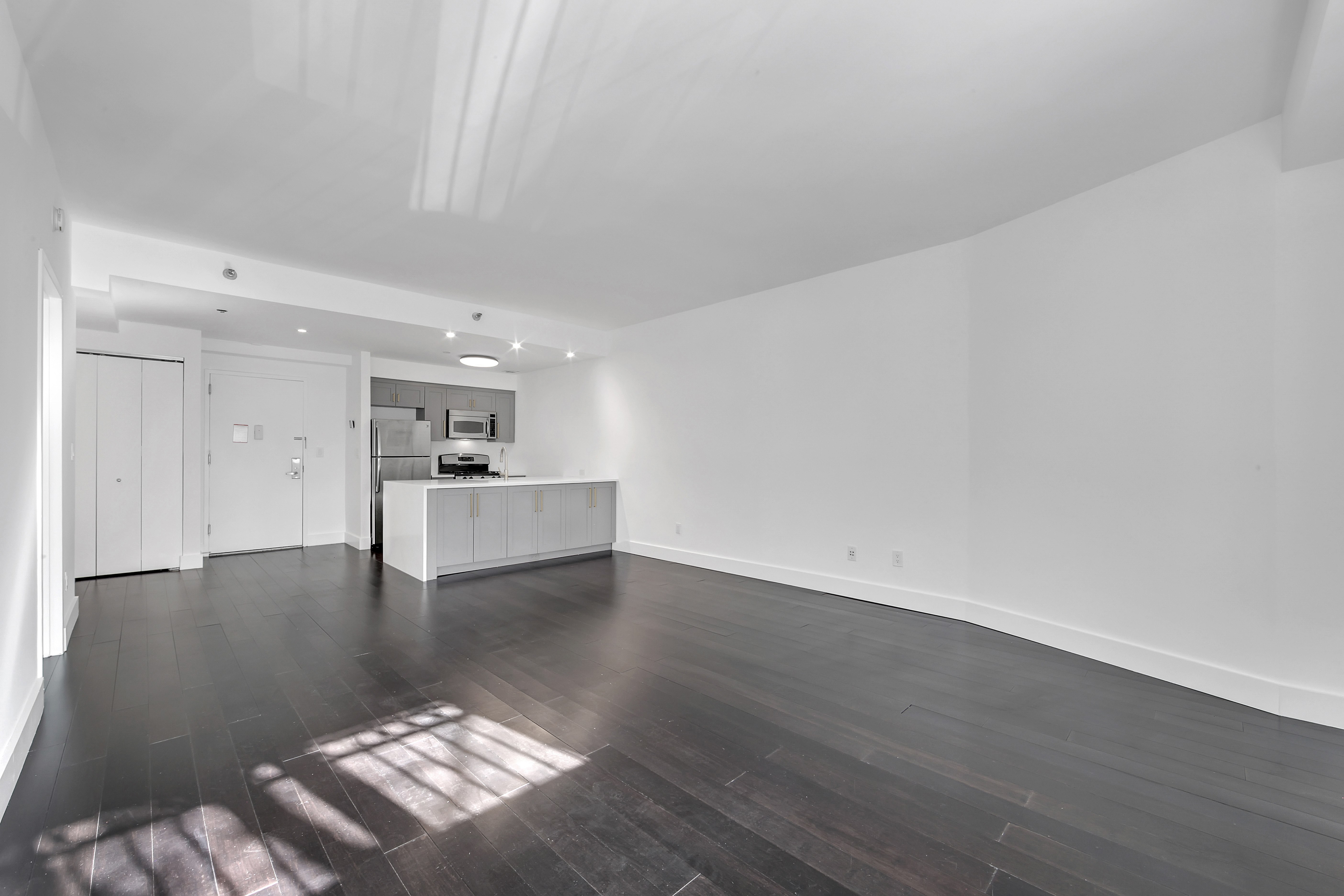 516 West 47th Street, Unit S1B Manhattan, NY 10036 - Photo 4 of 17 a view of kitchen and hall with wooden floor