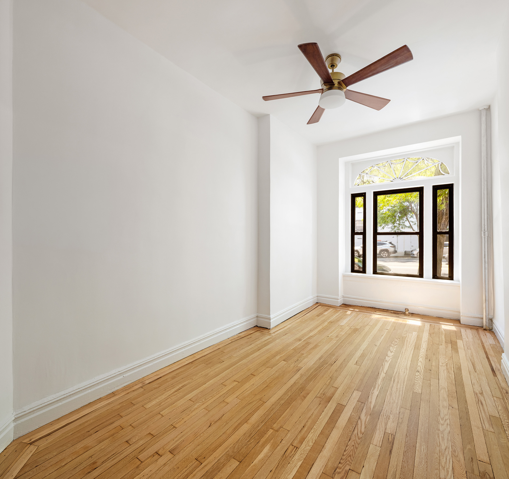 107 West 106th Street, Unit D Manhattan, NY 10025 - Photo 3 of 12 a view of an empty room with wooden floor and a window