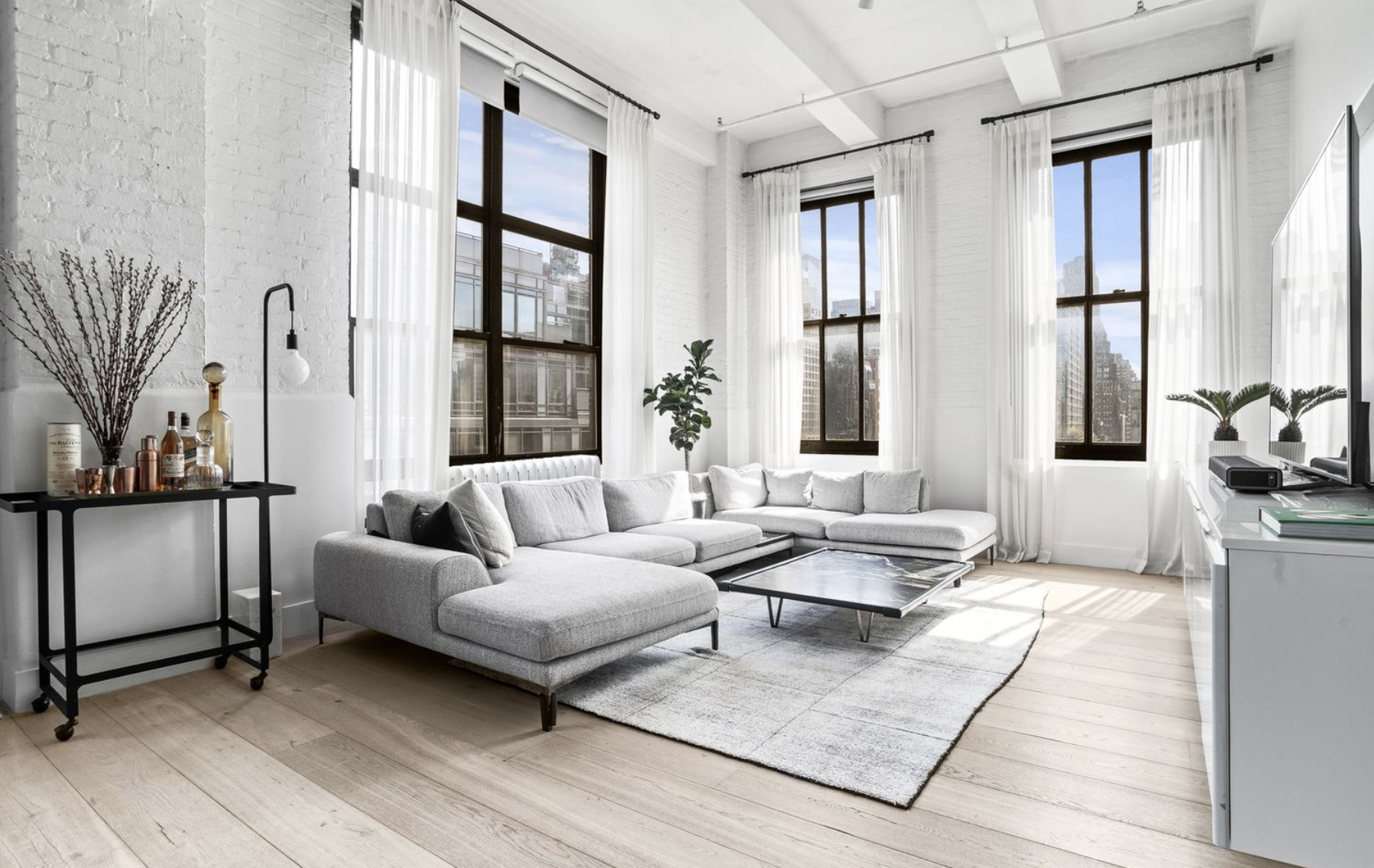 448 West 37th Street, Unit 8C Manhattan, NY 10018 - Photo 1 of 10 a living room with furniture and large windows