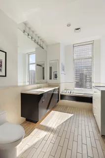 a spacious bathroom with a double vanity sink a mirror and a bathtub