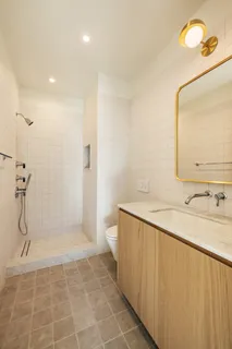 a bathroom with a granite countertop sink a toilet and mirror