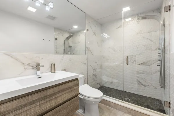 a bathroom with a sink a toilet and shower