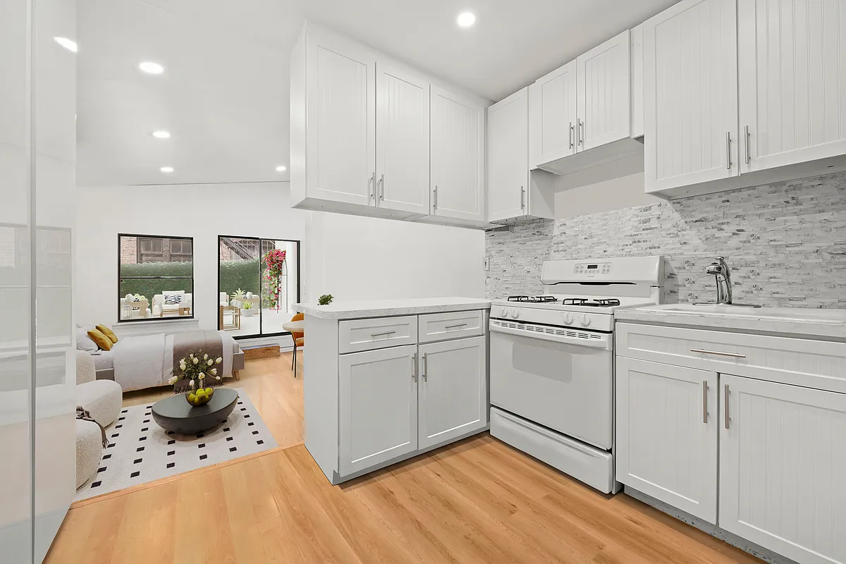 35 East 10th Street, Unit 2G Manhattan, NY 10003 - Photo 4 of 11 a kitchen with a sink cabinets and window