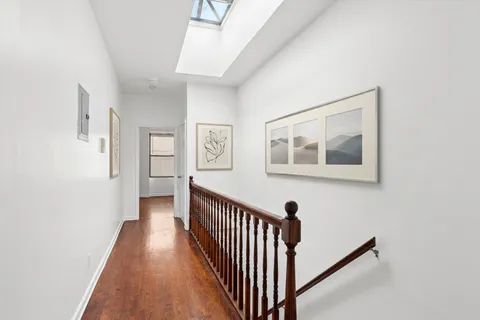 a view of a hallway with wooden floor and stairs
