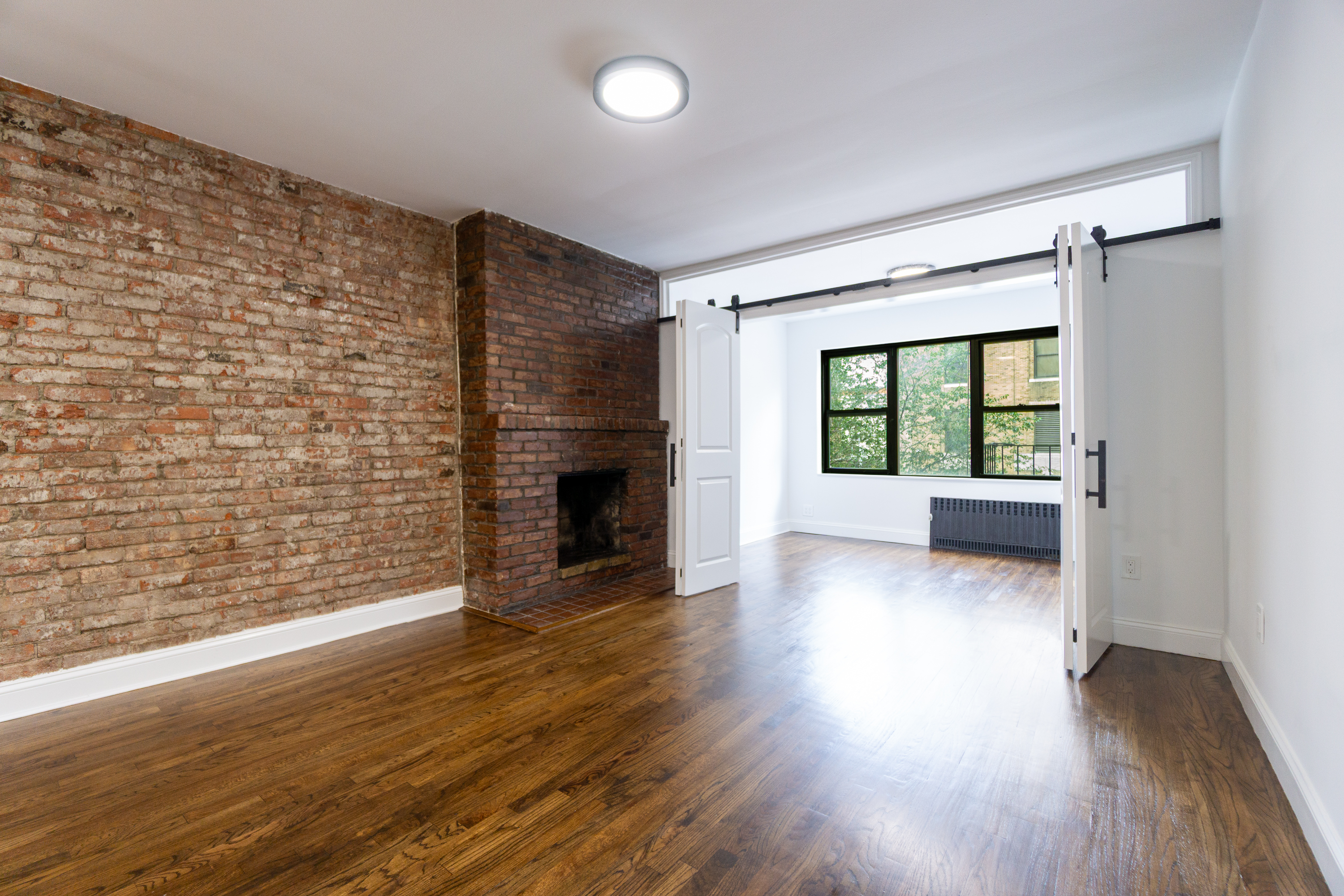 205 2nd Avenue, Unit 3B Manhattan, NY 10003 - Photo 3 of 9 wooden floor in an empty room with a window