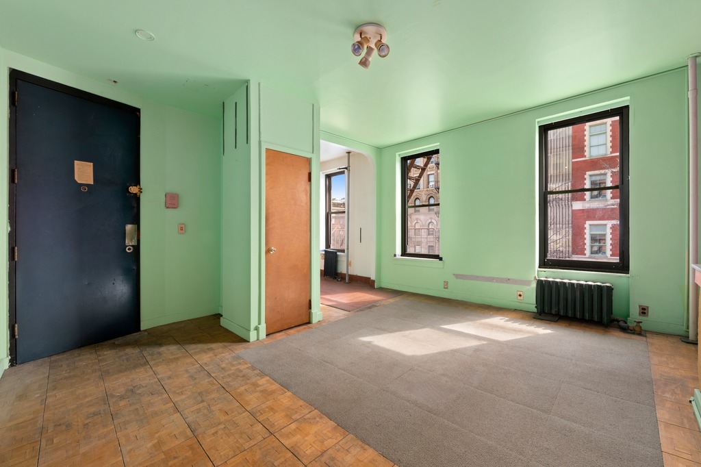 151 1st Avenue, Unit 3F Manhattan, NY 10003 - Photo 3 of 9 a view of an empty room with window and stairs