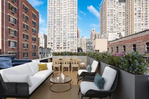 a living room with furniture and a potted plant