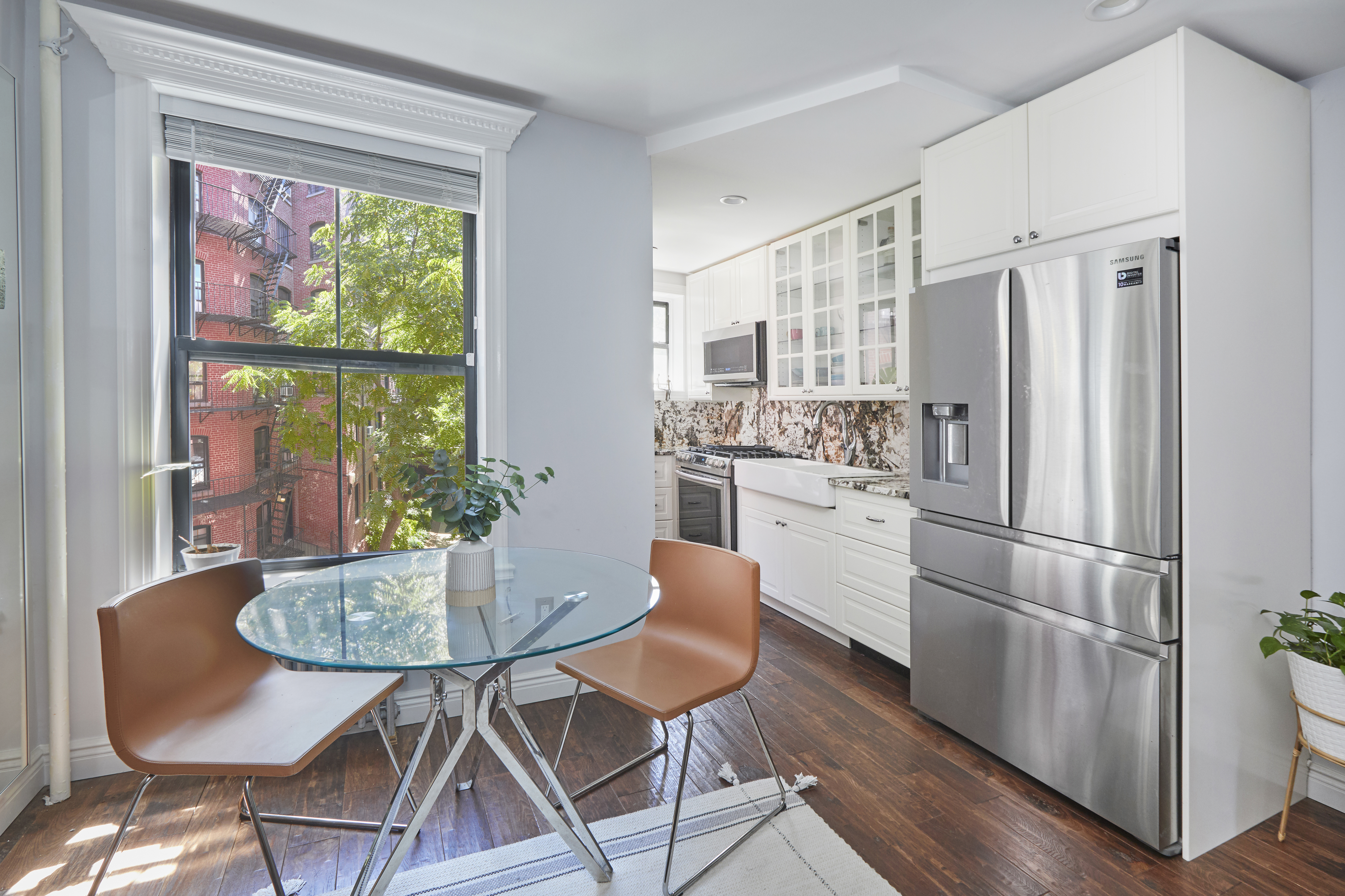 443 Hicks Street, Unit 3E Brooklyn, NY 11201 - Photo 2 of 7 a kitchen with stainless steel appliances granite countertop a refrigerator a kitchen island and chairs in it