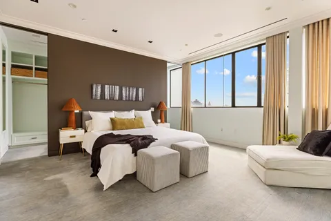 a bedroom with a bed and a large window