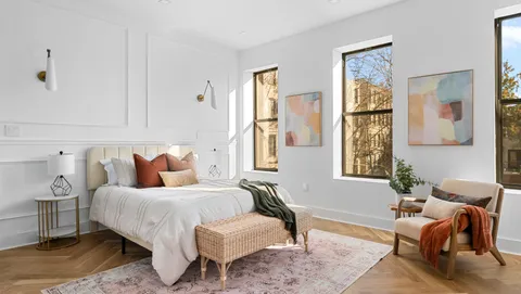 a bedroom with a bed and wooden floor