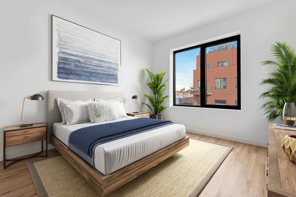 a bedroom with a large bed and a potted plant