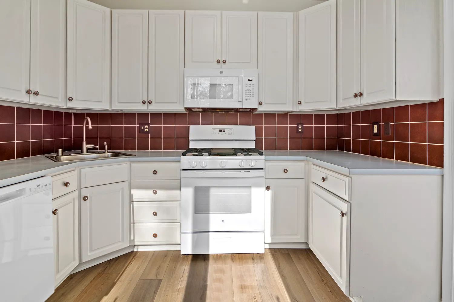 a kitchen with granite countertop white cabinets and white appliances