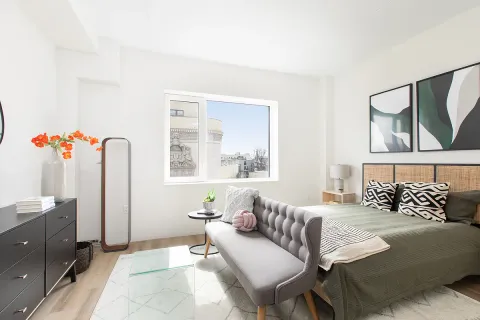 a bedroom with a bed couch and window