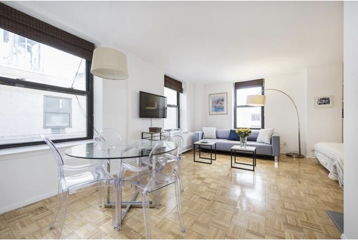 201 West 74th Street, Unit 16A Manhattan, NY 10023 - Photo 1 of 13 a living room with furniture and a flat screen tv