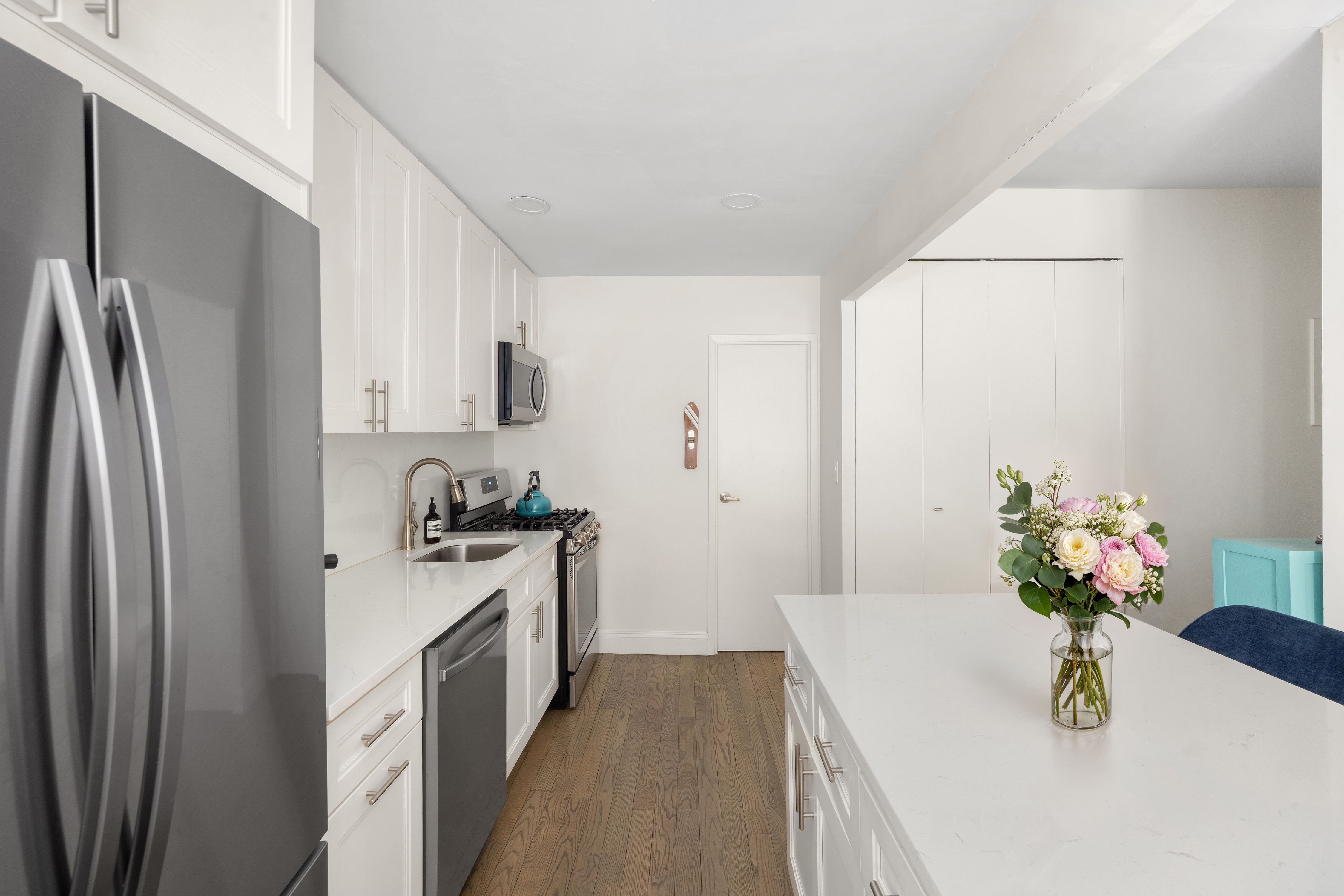 253 West 73rd Street, Unit 4N Manhattan, NY 10023 - Photo 5 of 9 a kitchen with stainless steel appliances granite countertop a refrigerator a stove a sink dishwasher and white cabinets with wooden floor
