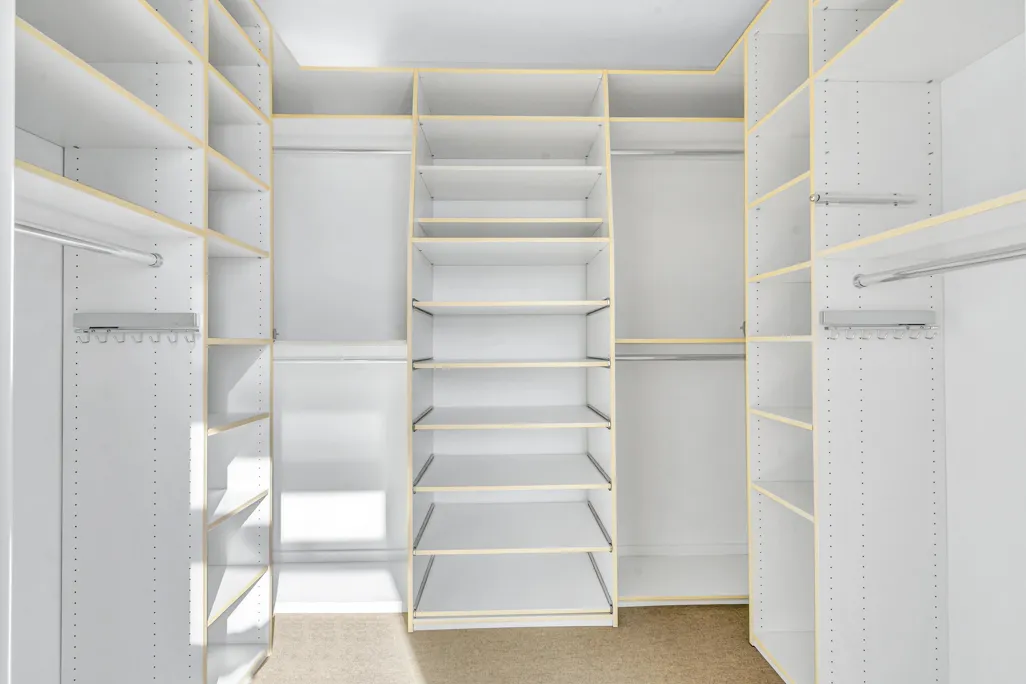 a view of walk in closet with empty racks