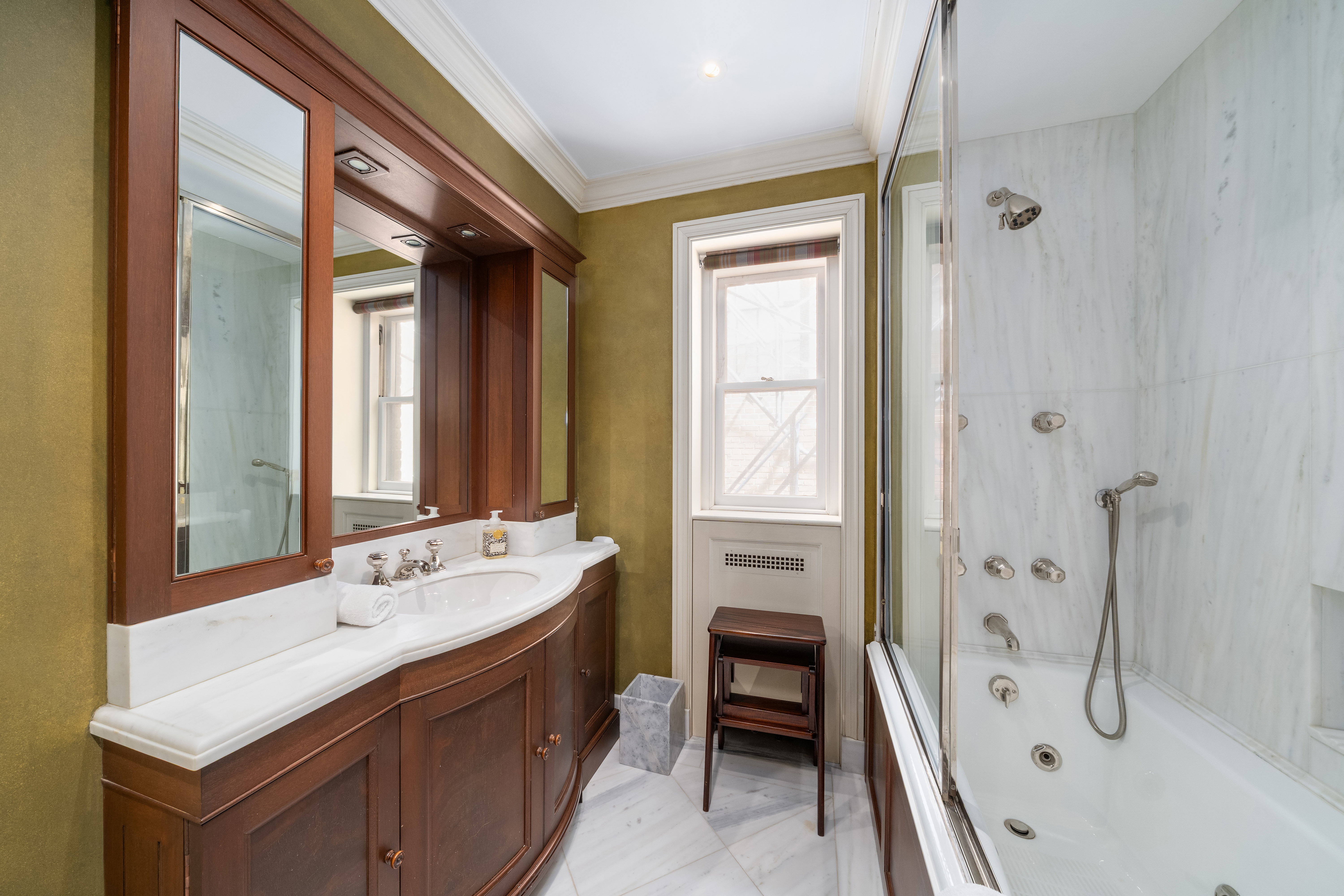 46 East 71st Street Manhattan, NY 10021 - Photo 18 of 27 a spacious bathroom with a double vanity sink a large mirror and a bathtub
