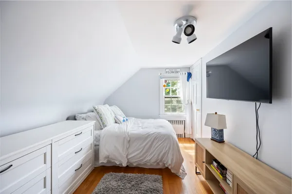 a spacious bedroom with a bed and a flat screen tv